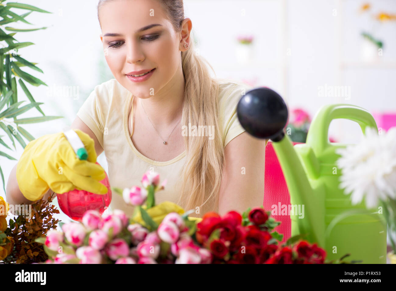 Young woman watering plants in her garden Stock Photo - Alamy