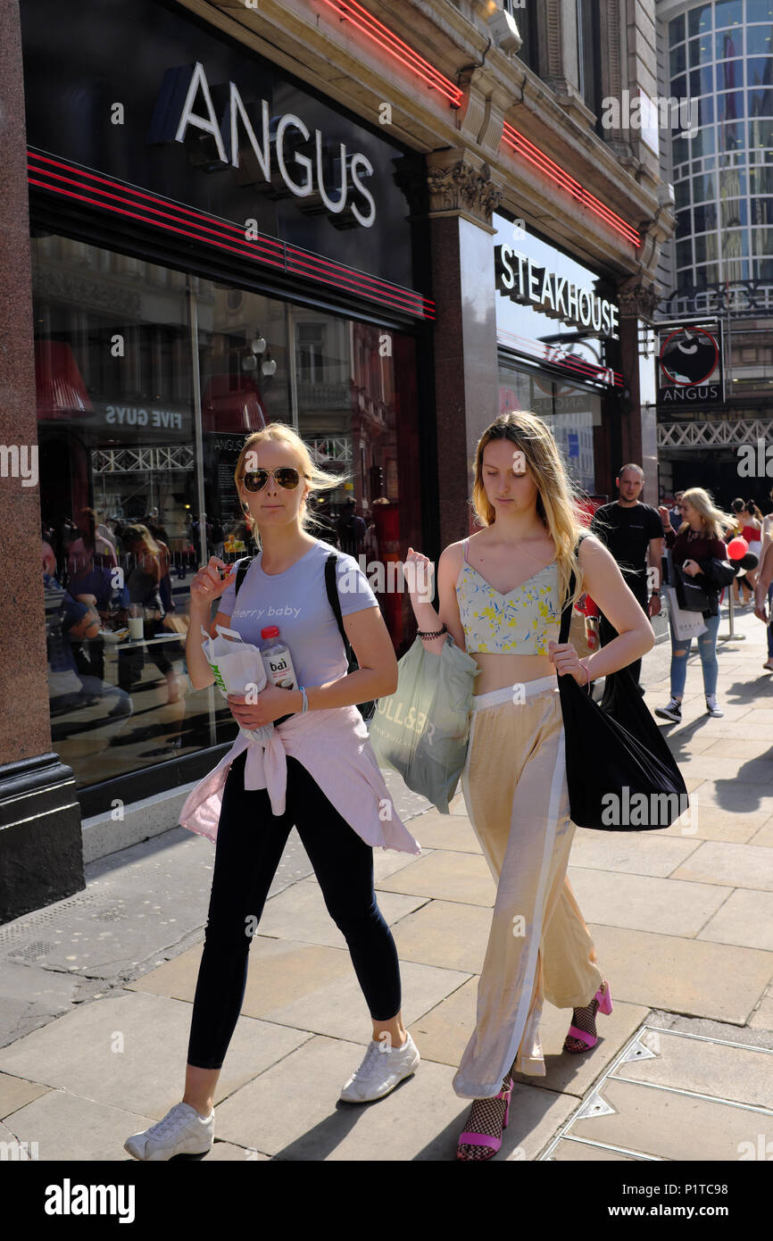 Girls walking by Angus Steakhouse, Piccadilly Circus, London, England, UK Stock Photo