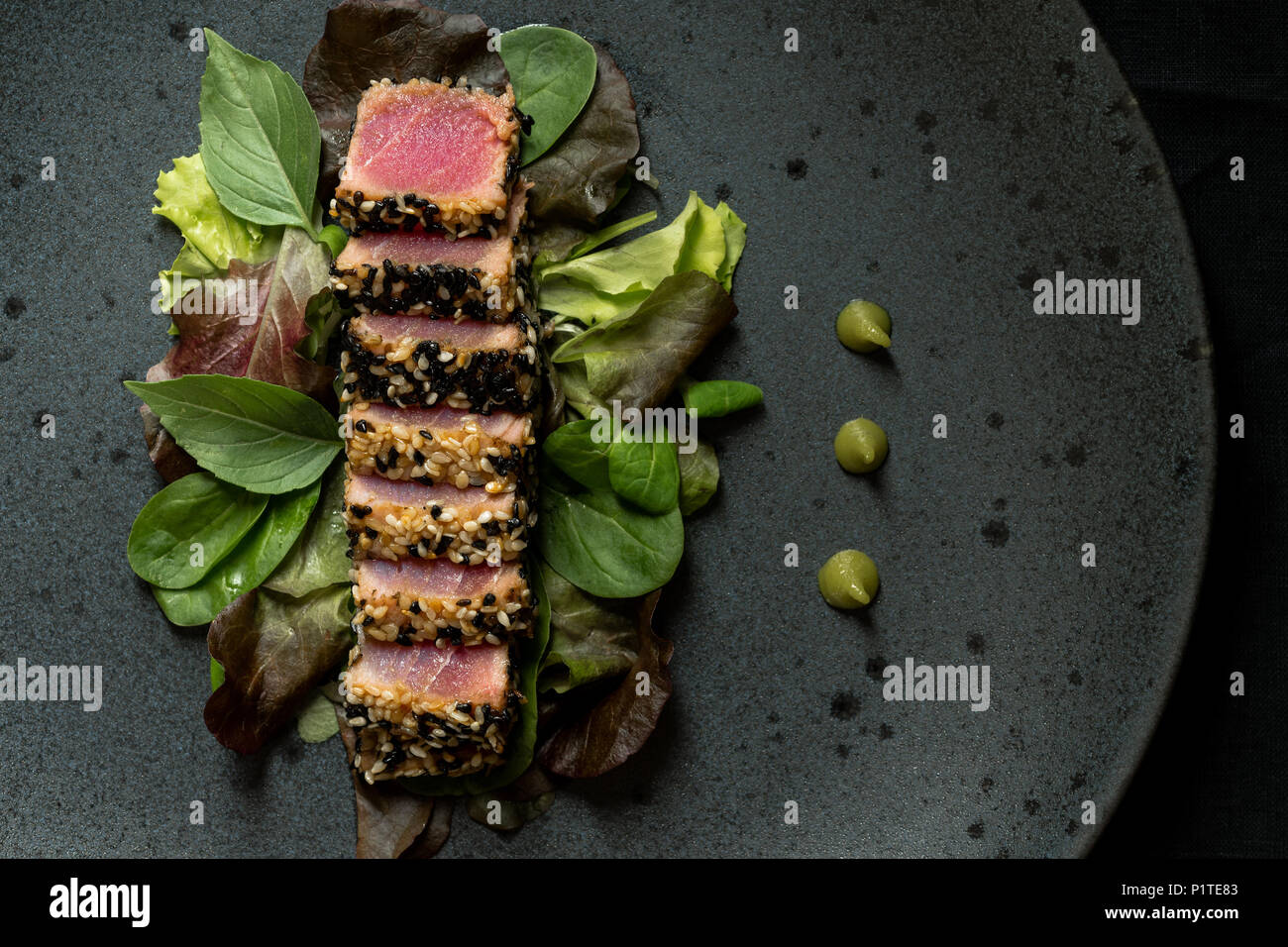Grilled Sliced Tuna Steak in Sesame with Salad and Wasabi Sauce Stock Photo