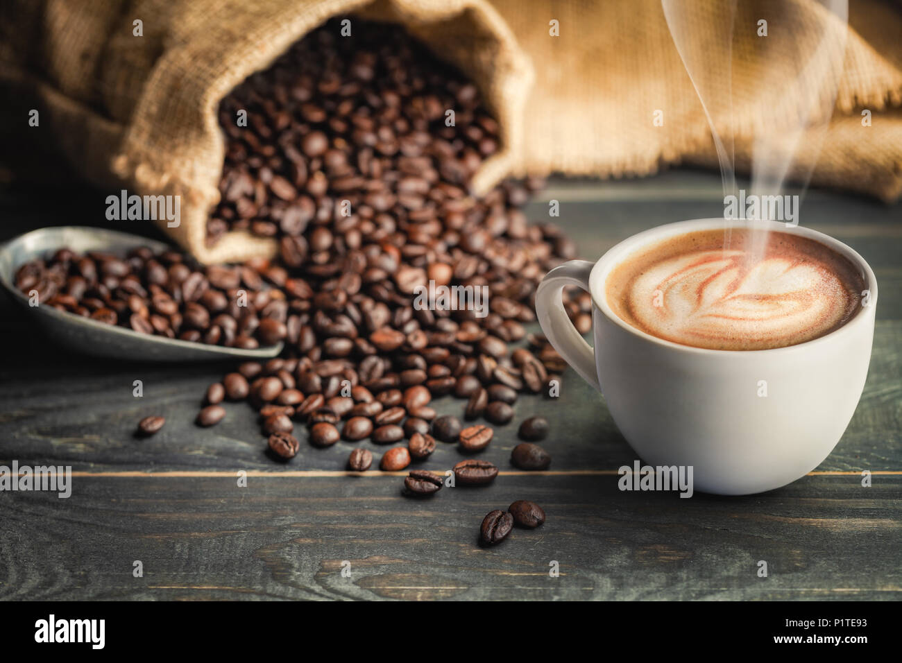 Coffee cup and coffee beans with bag, scoop and smoke - classic concept. Stock Photo