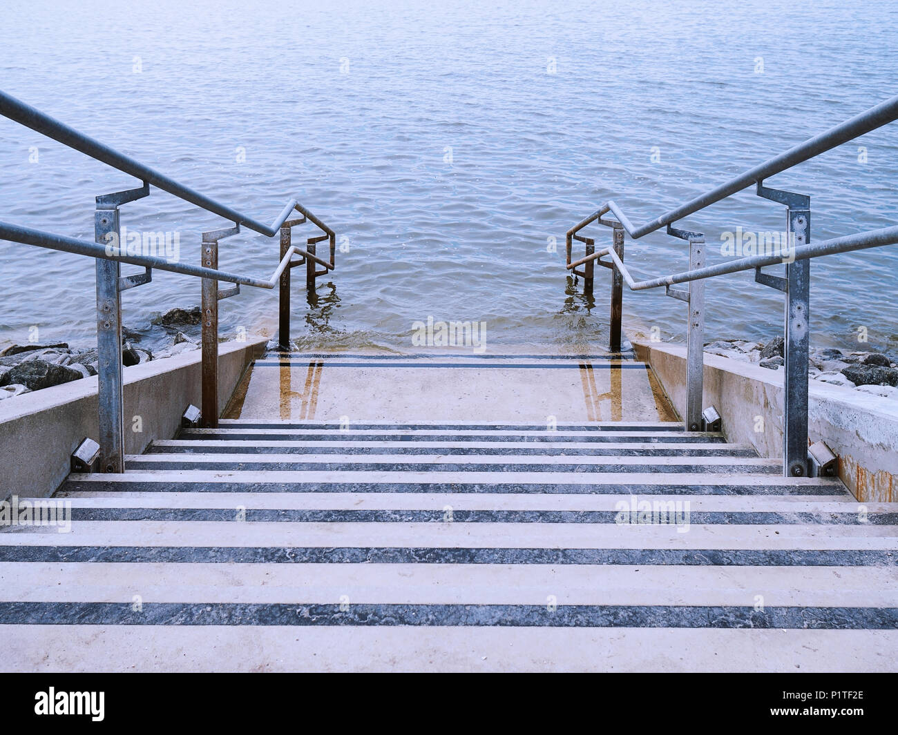 concrete stairs or steps leading down into ocean water Stock Photo
