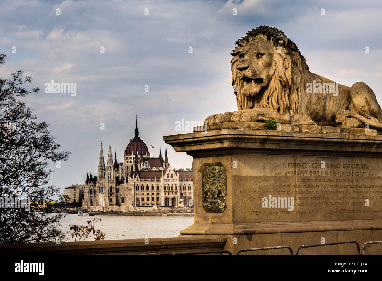View from the Chain Bridge, guarded by a lion, across the Danube river towards the Parliament of Hungary in Budapest Stock Photo
