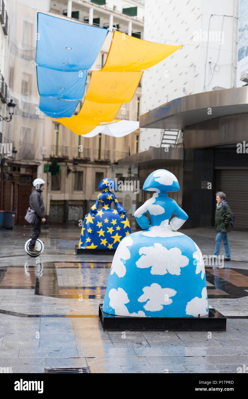 Madrid, Spain: Pedestrians pass two 'Menina' sculptures along Calle de Preciados. The  sculptures are part of the 'Meninas Madrid Gallery' in tribute  Stock Photo