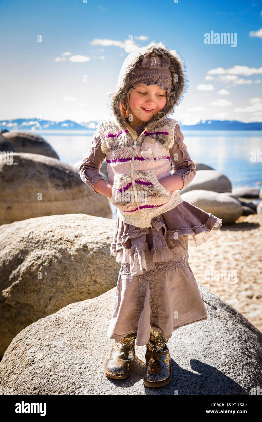 Stylish young girl in gold boots showing off rural, hippie kids fashion