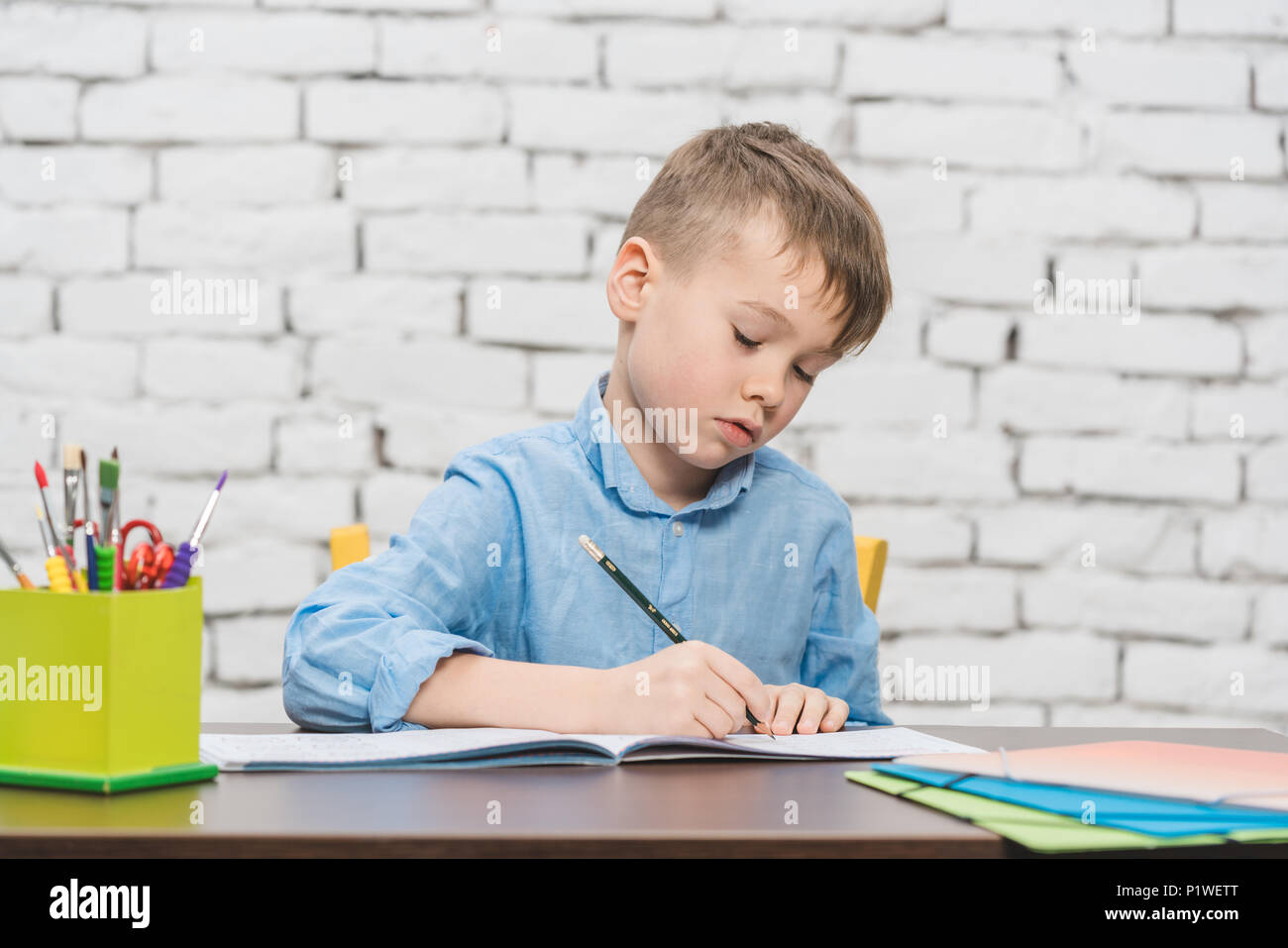 Young boy learning for school with his books Stock Photo - Alamy