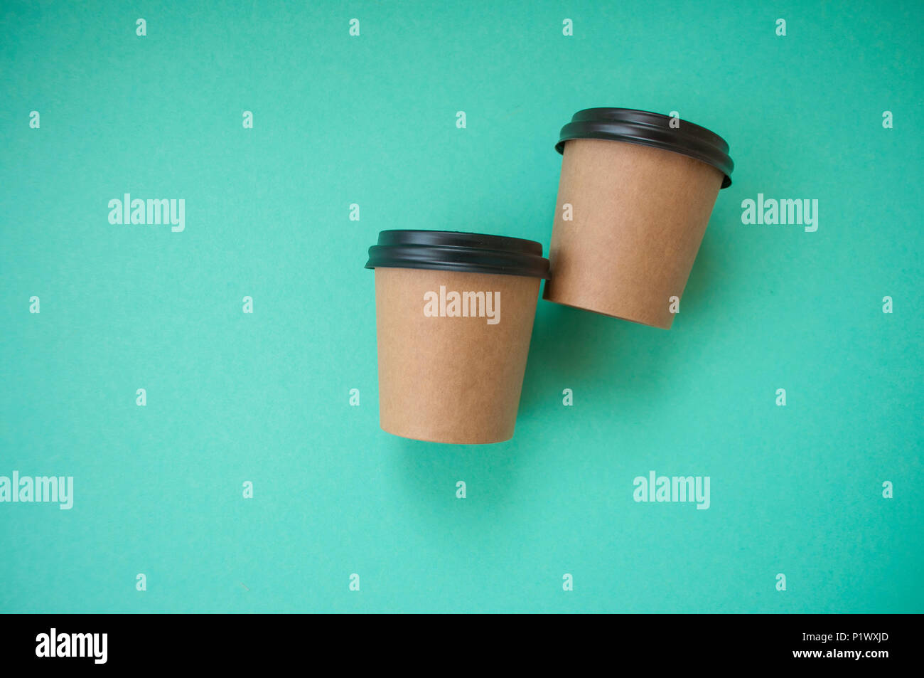 Two paper cups for hot drinks on blue background with text space. Stock Photo