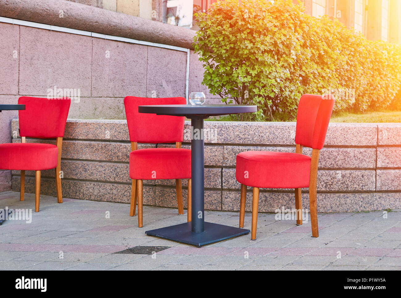 Comfortable chairs standing on pavement near small table in nice outdoor cafe on sunny day