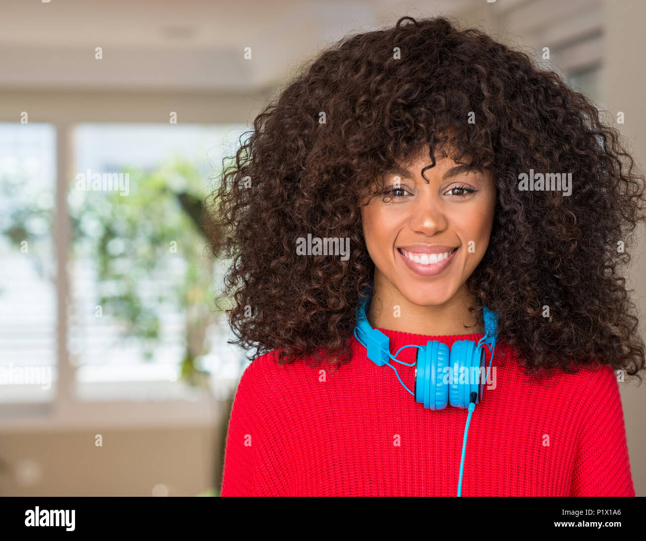 African american woman wearing headphones with a happy and cool smile ...