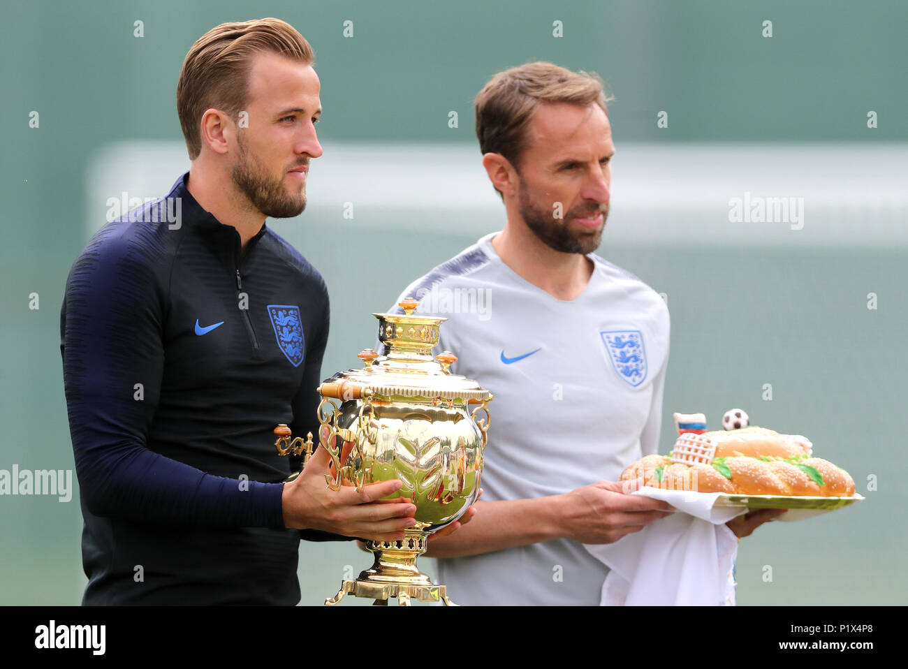England's Harry Kane (left) and manager Gareth Southgate receive a Russian samovar - a heated metal container traditionally used to heat and boil water, and a karavai - a large round loaf of bread, both symbolizing hospitality during the training session at the Spartak Zelenogorsk Stadium, Repino. Stock Photo