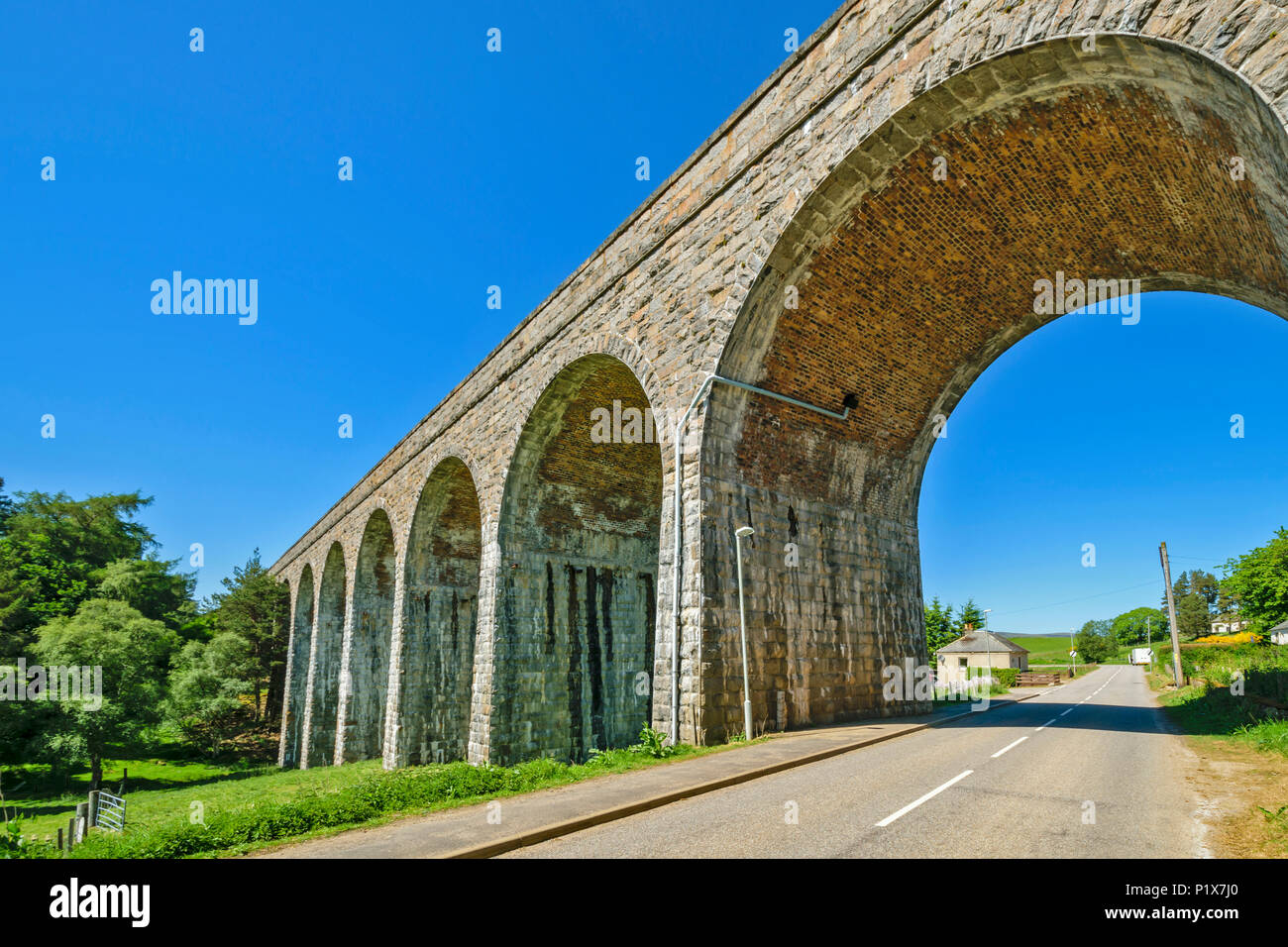 TOMATIN STONE RAILWAY VIADUCT WITH LARGE ARCHWAY OVER THE ROAD Stock Photo