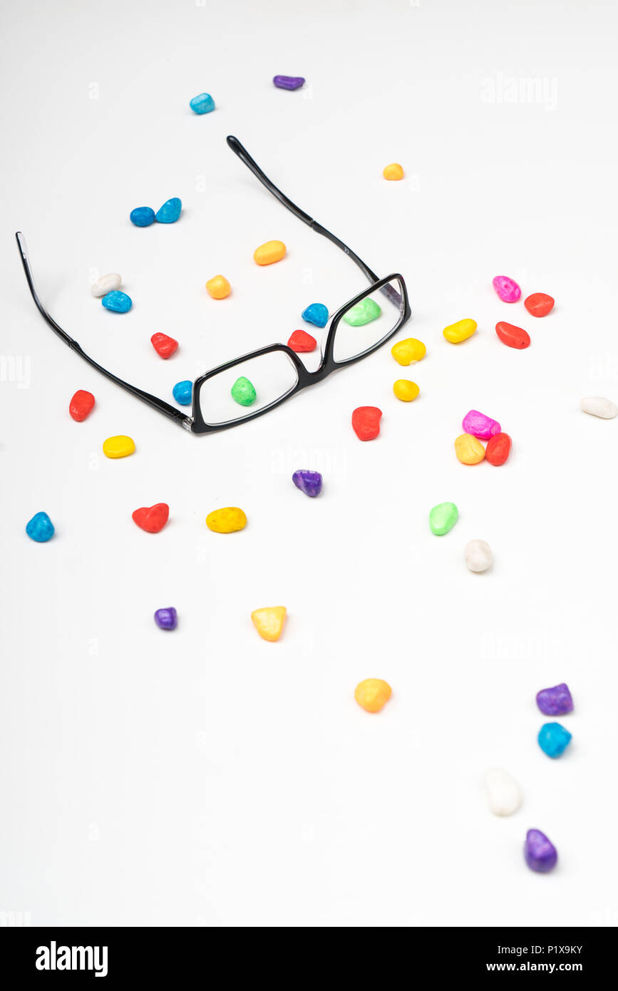 a pair of glasses between small colored stones Stock Photo