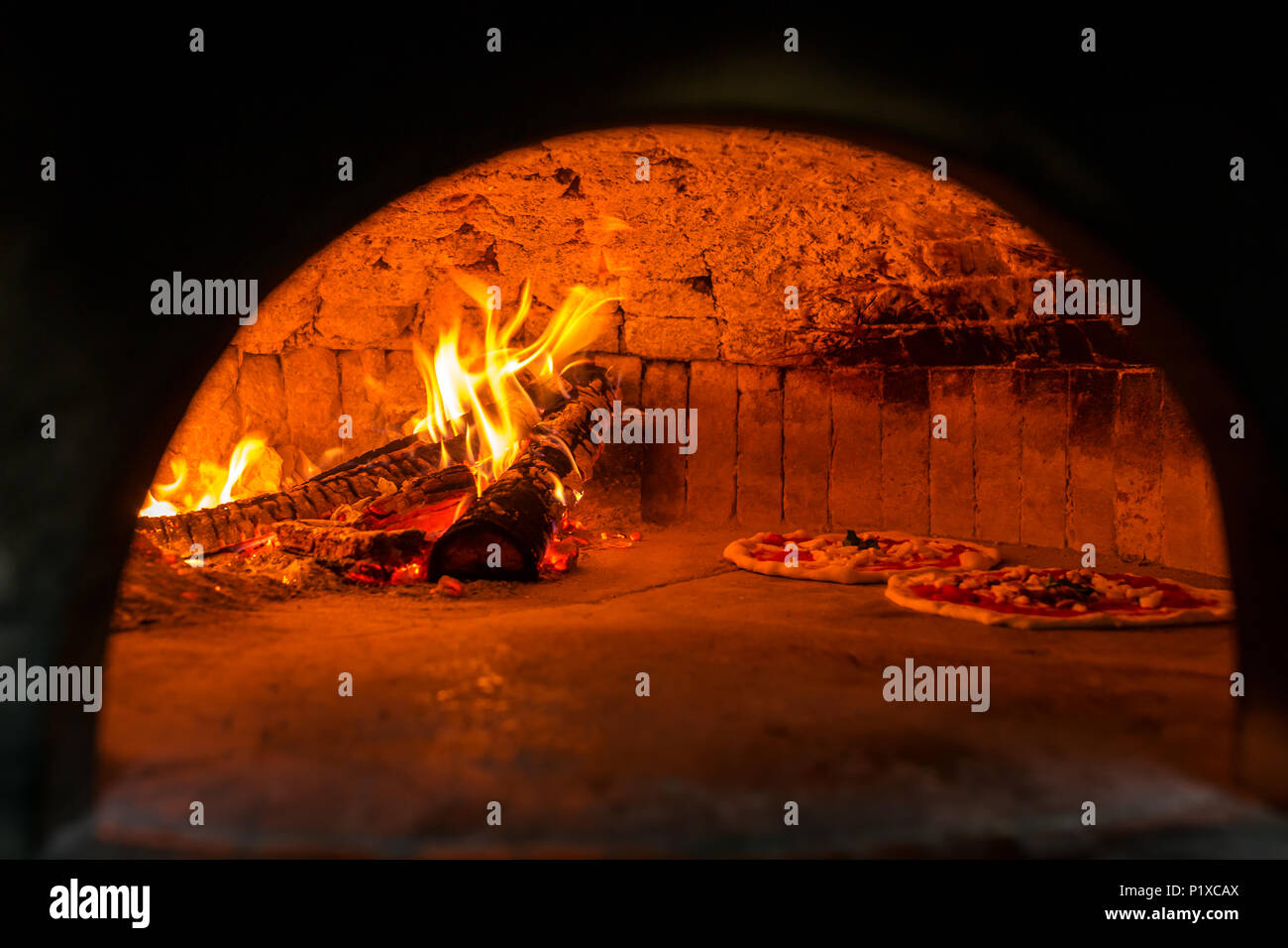 Original neapolitan pizza margherita in a traditional wood oven in Naples restaurant, Italy Stock Photo