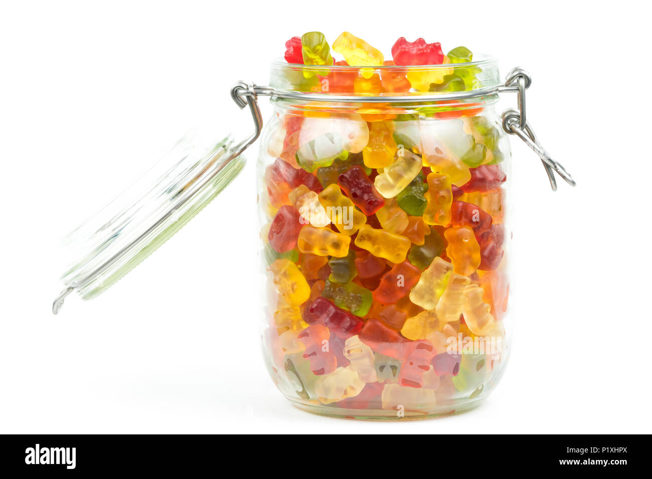 Colourful gummy bears / jelly baby candy sweets in an open glass jar on a white background Stock Photo