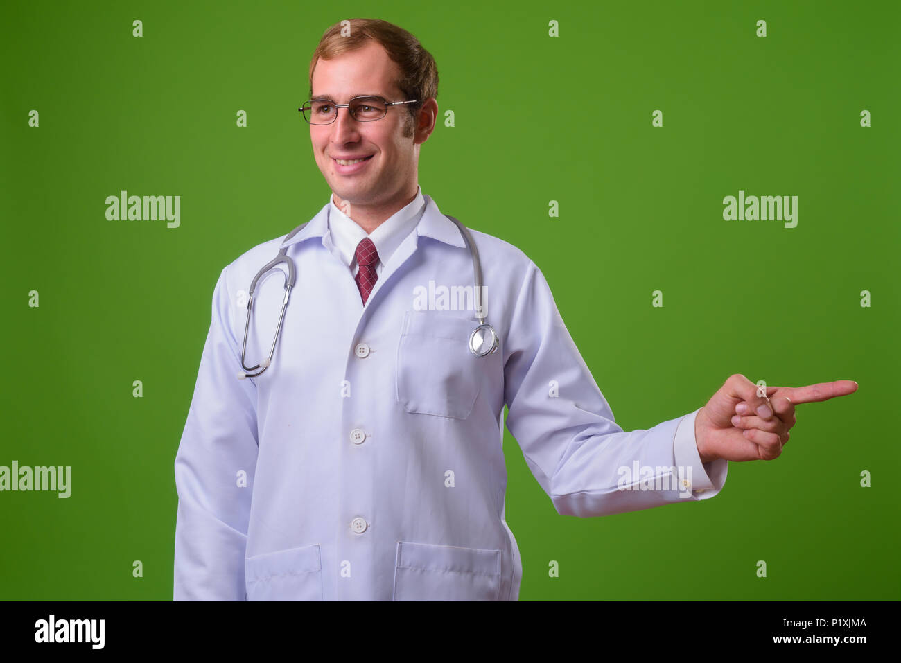 Young man doctor against green background Stock Photo