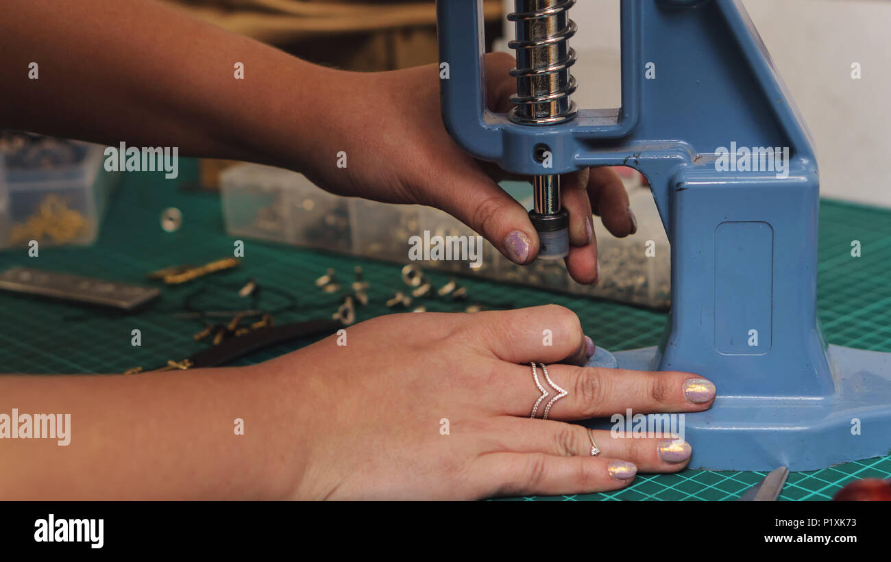 Tanner puts rivets on leather bracelet. Close-up photo. Process of ...