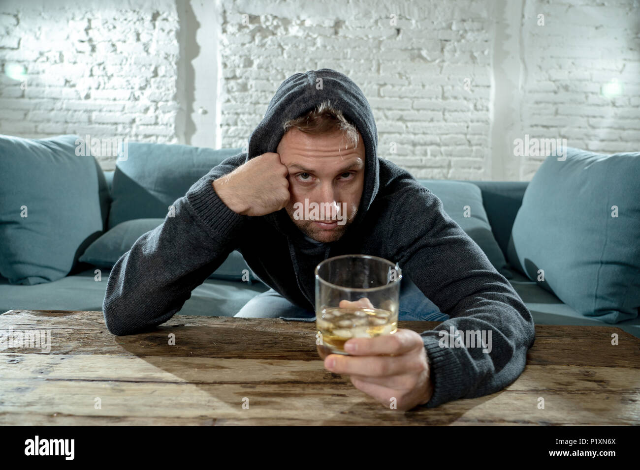 drunk alcoholic unemployed man drinking whiskey from the glass and