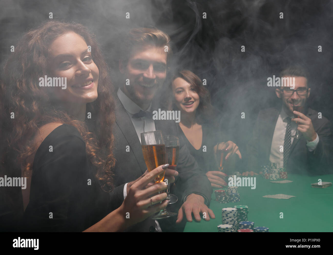 group of friends sitting at game table in casino Stock Photo - Alamy