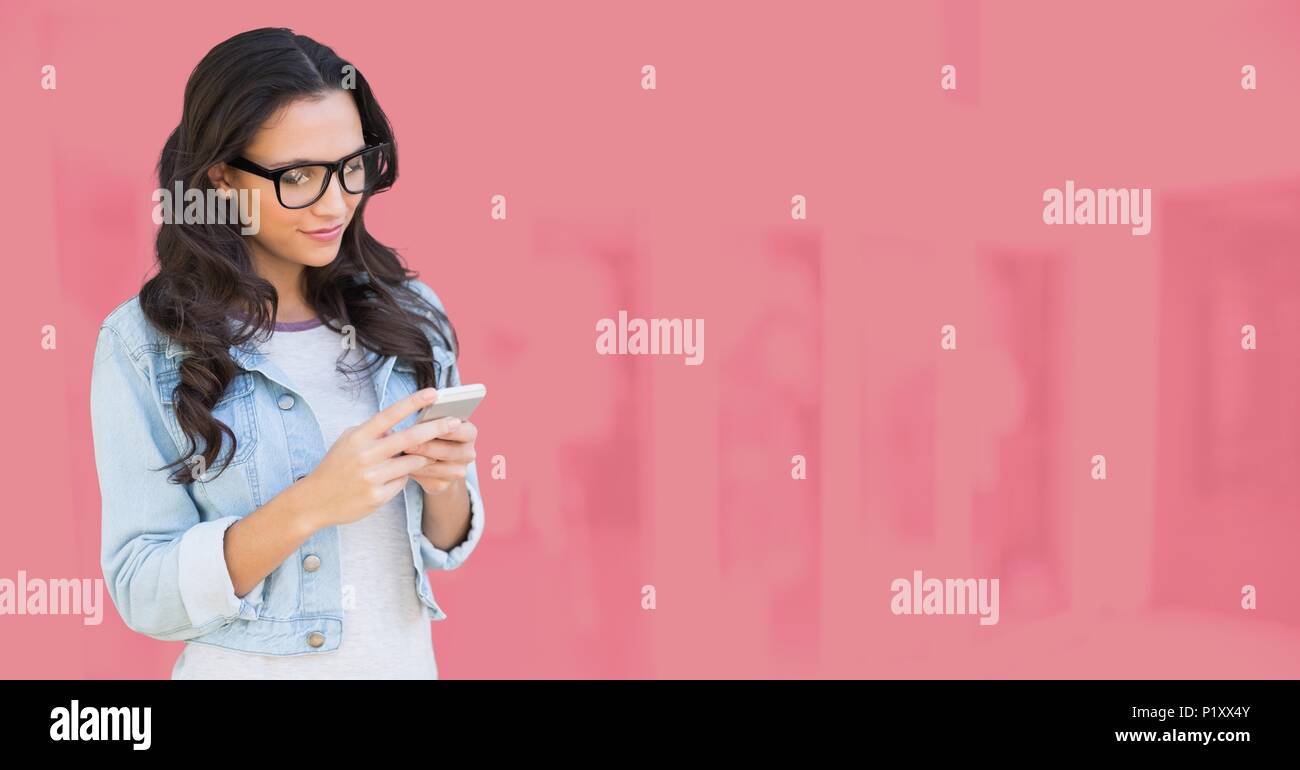 Woman using phone with pink background Stock Photo