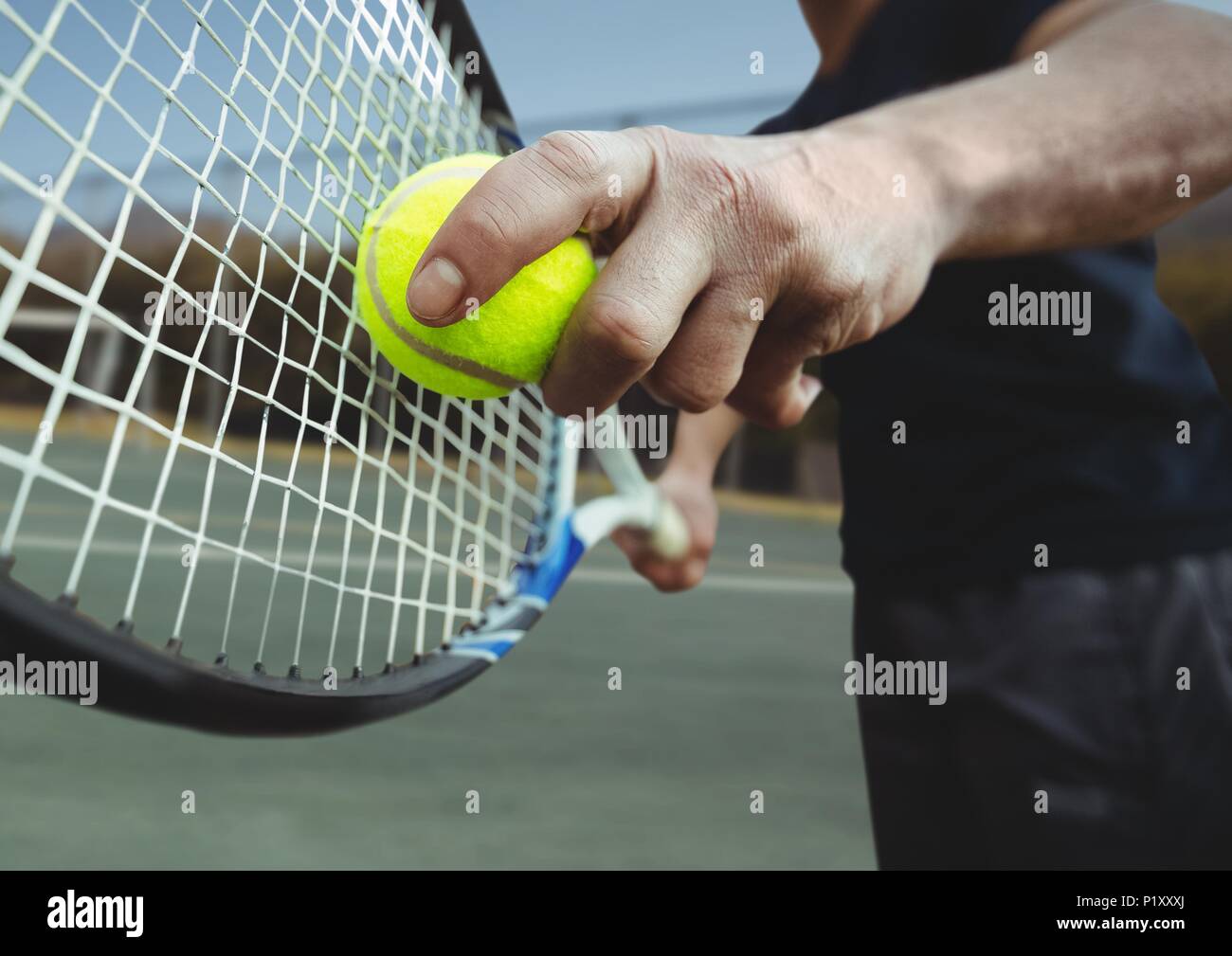 Tennis player holding racket on court with racket Stock Photo