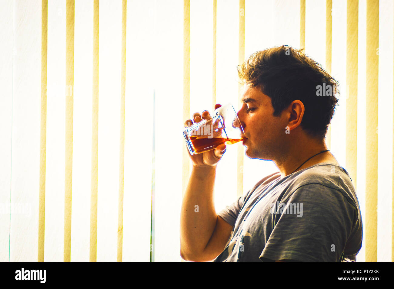 Young adult drinking whisky alcoholism concept man with drinking problems depression in young adults Stock Photo