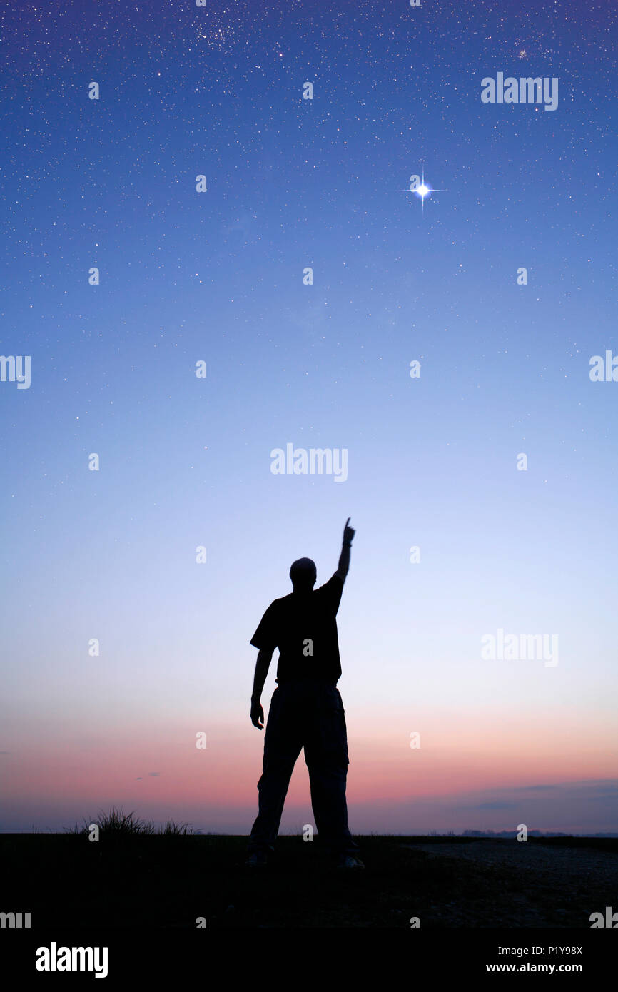 The Seine and Marne. Man indicating a brilliant star in the sky, at the time of the twilight. Stock Photo