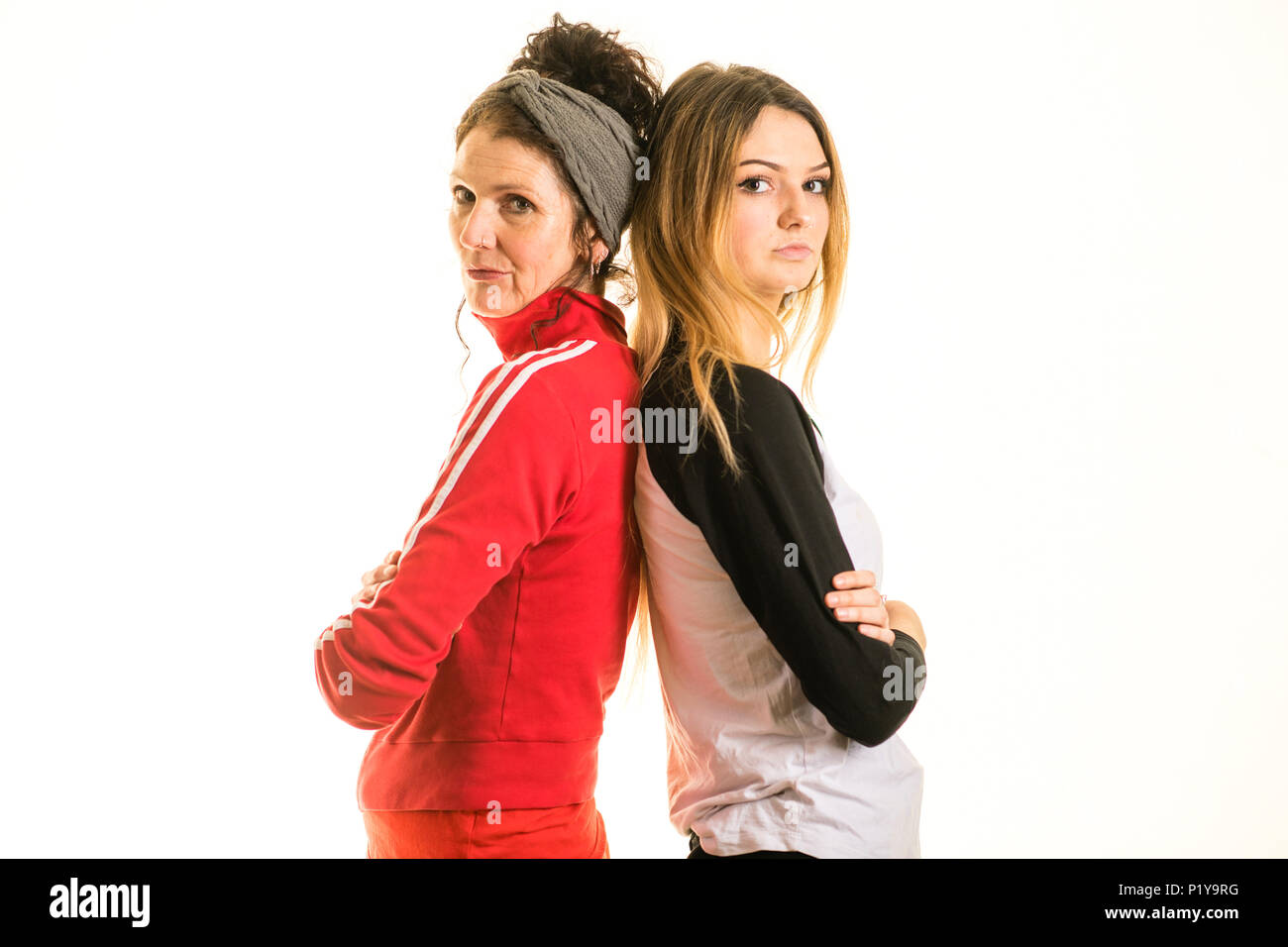 A young blonde 17 year old teenage girl with her mother, back to back