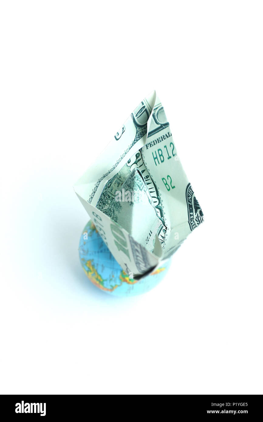 globe and a paper boat out of a dollar bill Stock Photo