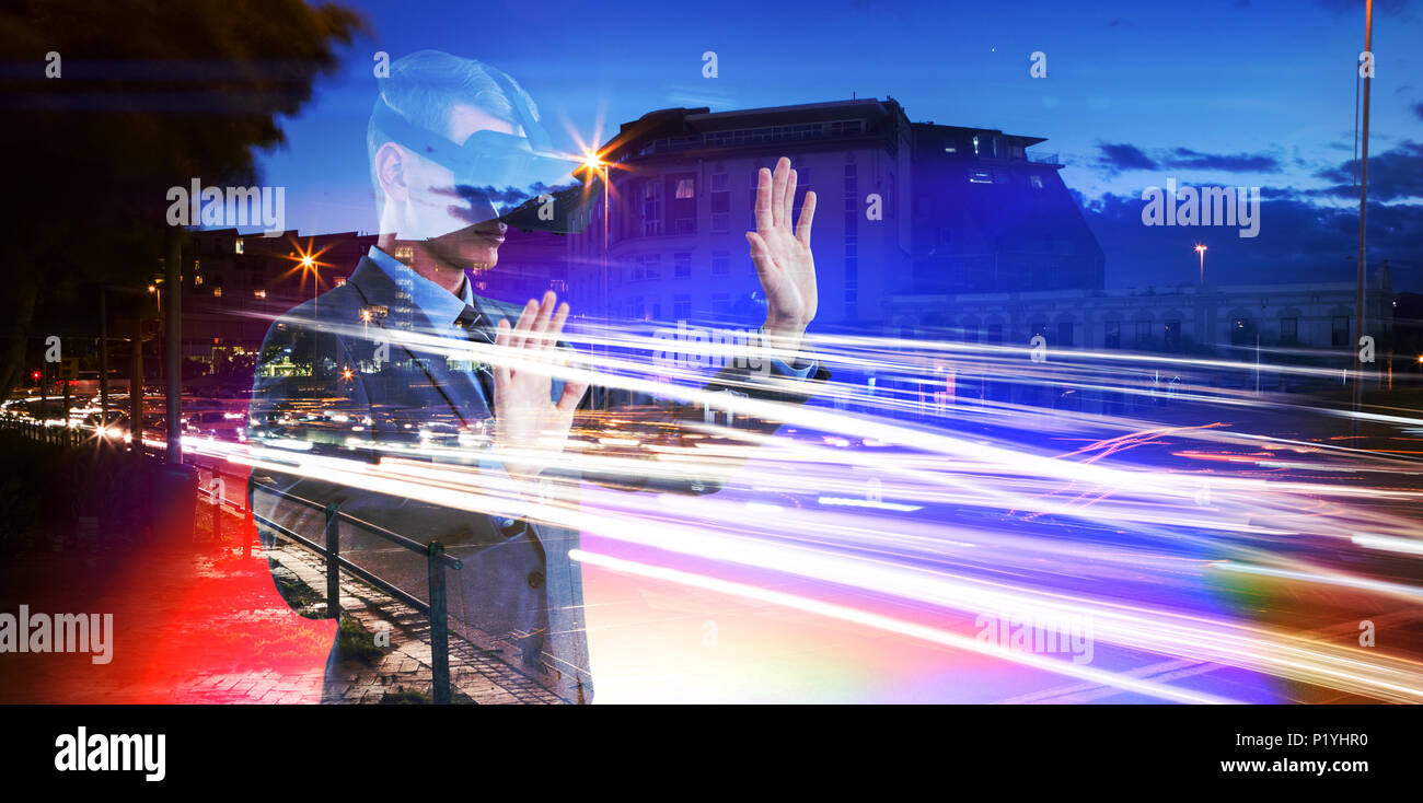 Composite image of businessman using virtual reality headset Stock Photo