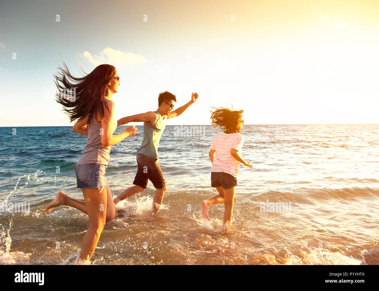 happy family running on the beach Stock Photo