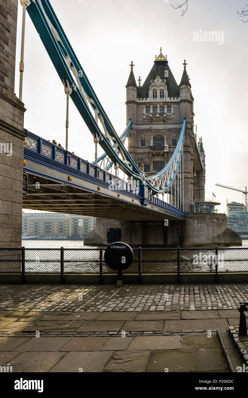 Low angle view of the Tower bridge, London with lifebuoy in the foreground. The bascule and suspension bridge crosses the River Thames and has become  Stock Photo