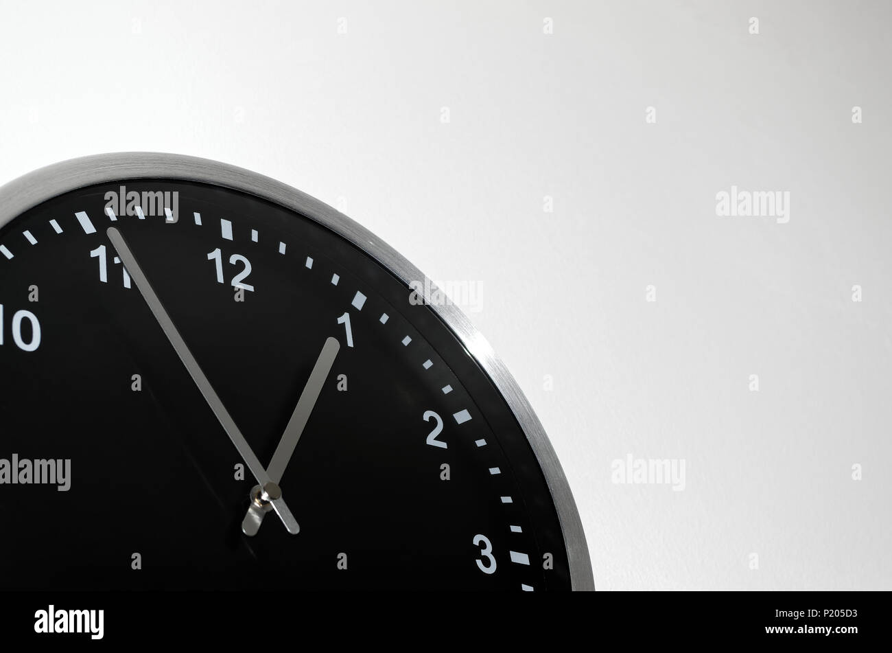 Five to one setting on the black wall clock Stock Photo - Alamy