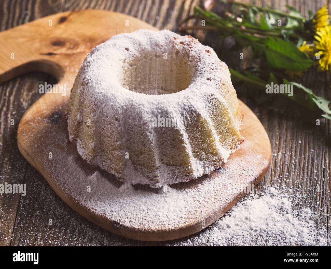Homemade Ring Cake With Icing Sugar On A Rural Wooden Board On The Background Of Spring Dandelions Retro Tones Stock Photo Alamy
