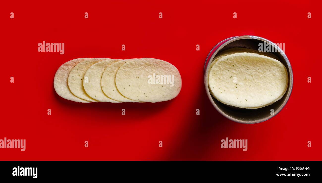 Close up of stacked potato chips - isolated on red background. Stock Photo