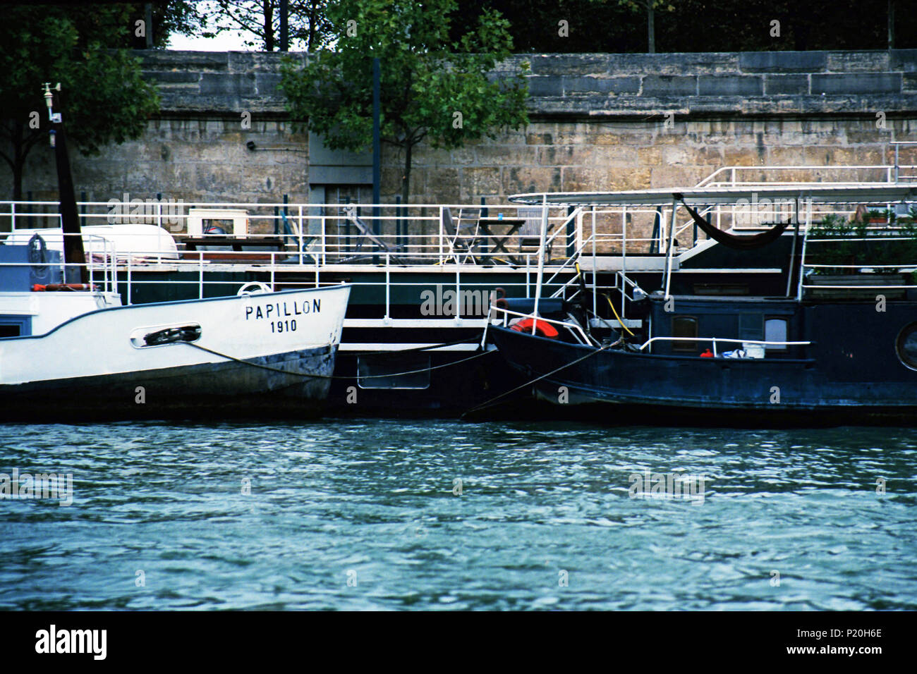 House boats parked several deep along the banks of the Siene River in Paris. Stock Photo