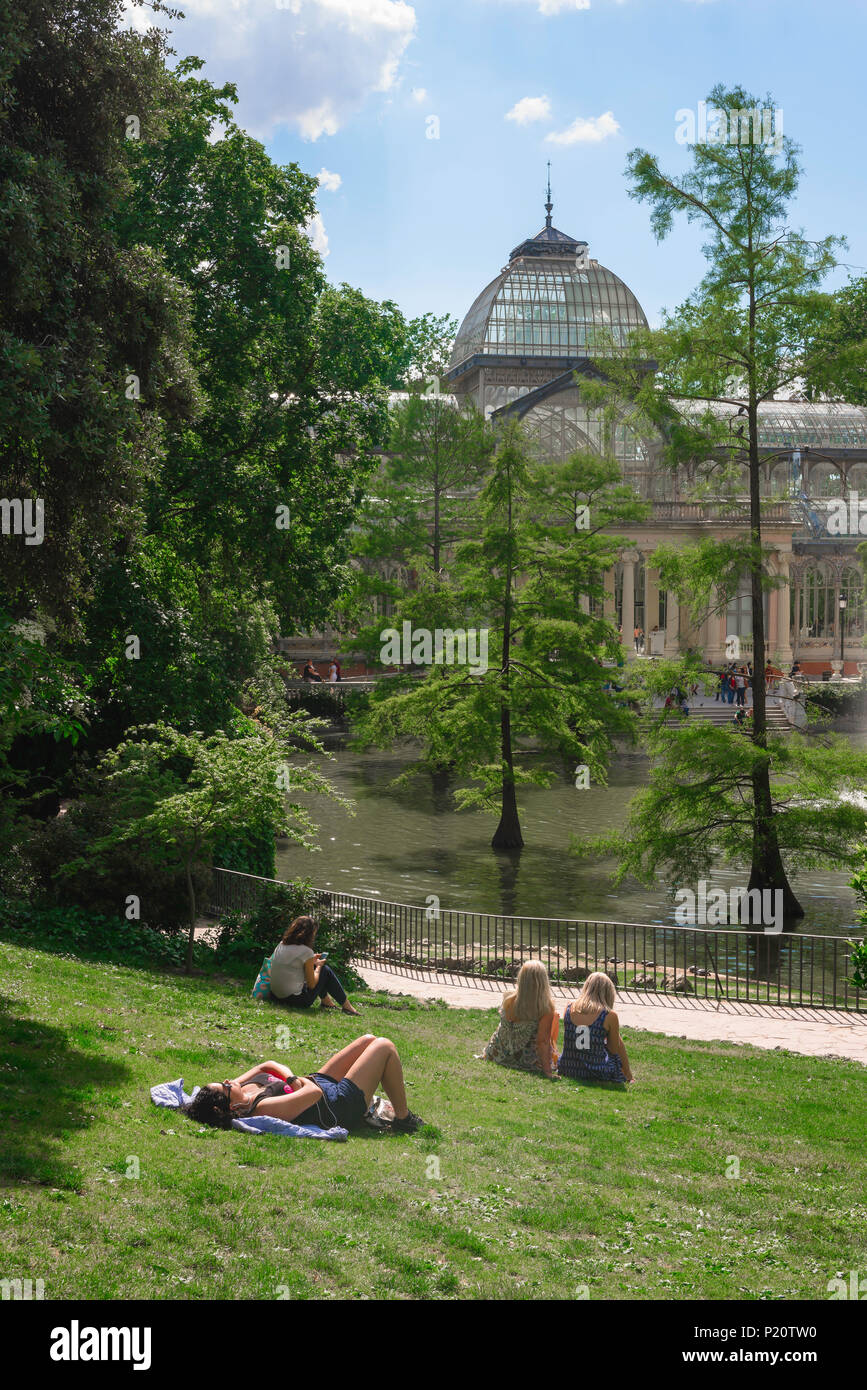 Madrid park summer, view of people relaxing on a summer afternoon near the Palacio Cristal in the Parque del Retiro, Madrid, Spain. Stock Photo