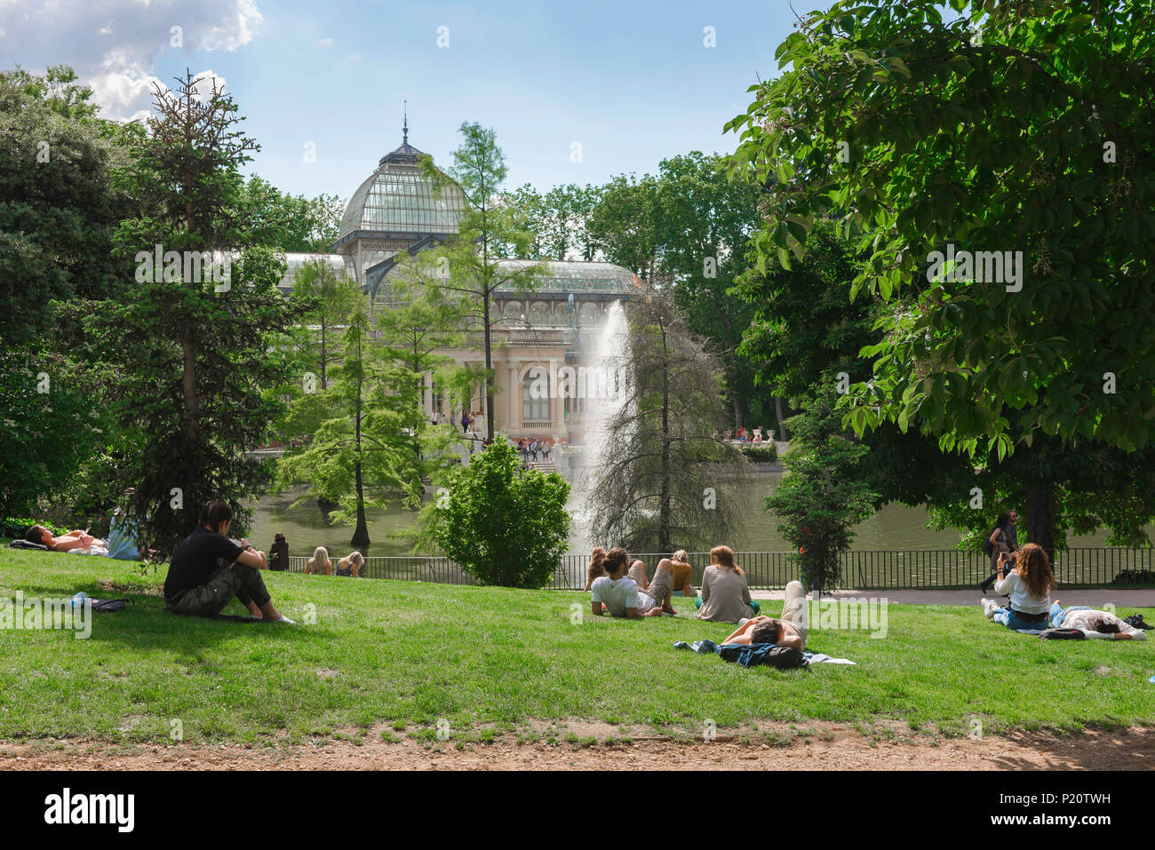 Madrid park summer, view of young people relaxing on a summer afternoon near the Palacio Cristal in the Parque del Retiro, Madrid, Spain. Stock Photo