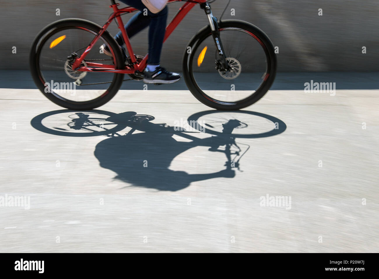 Blurry cyclist silhouette and shadow on a bike Stock Photo