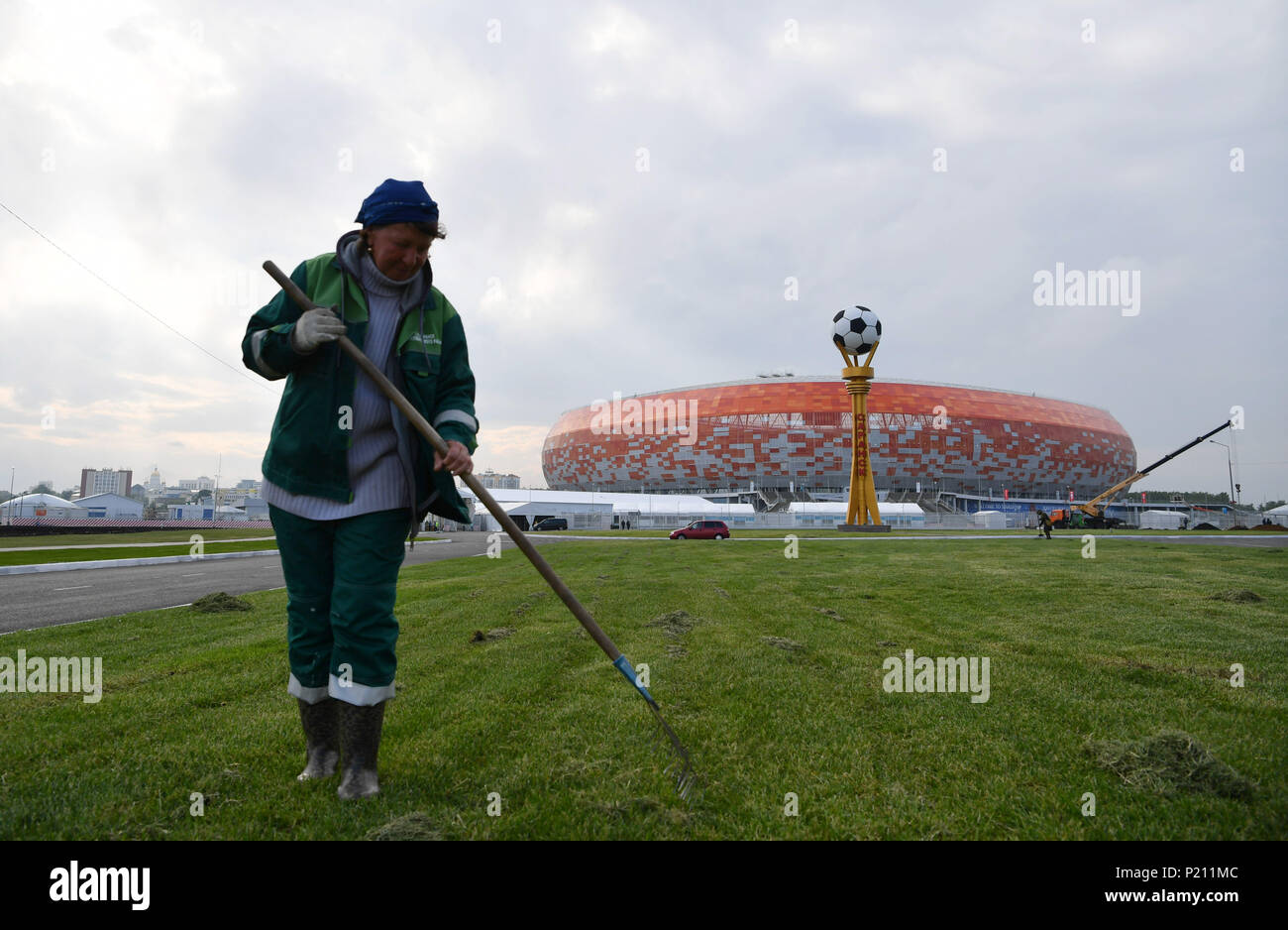 Saransk. 13th June, 2018. A staff member trims a lawn in front of the Mordovia Arena, which will host four group phase matches during the 2018 FIFA World Cup, in Saransk, Russia. Credit: Lui Siu Wai/Xinhua/Alamy Live News Stock Photo