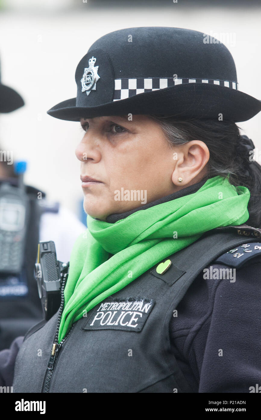 London UK. 14th June 2018. A police officer wearing a green scarfe  to mark the Grenfell anniversary a year after the fire  in West London which claimed the lives of 72 residents in the tower block.  A minute's silence will be observed nationally at midday to remember the victims of the Grenfell fire on 14 June 2017. Credit: amer ghazzal/Alamy Live News Stock Photo