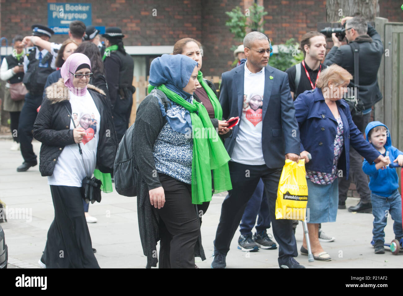 London UK. 14th June 2018. Members of the public wearig green scarves to mark the Grenfell anniversary a year after the fire  in West London which claimed the lives of 72 residents in the tower block.  A minute's silence will be observed nationally at midday to remember the victims of the Grenfell fire on 14 June 2017. Credit: amer ghazzal/Alamy Live News Stock Photo