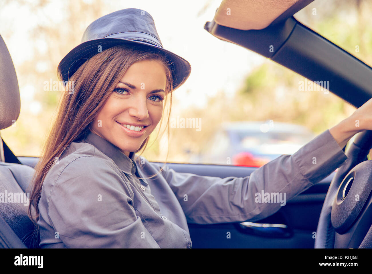 Happy woman driving convertible on sunny day Stock Photo