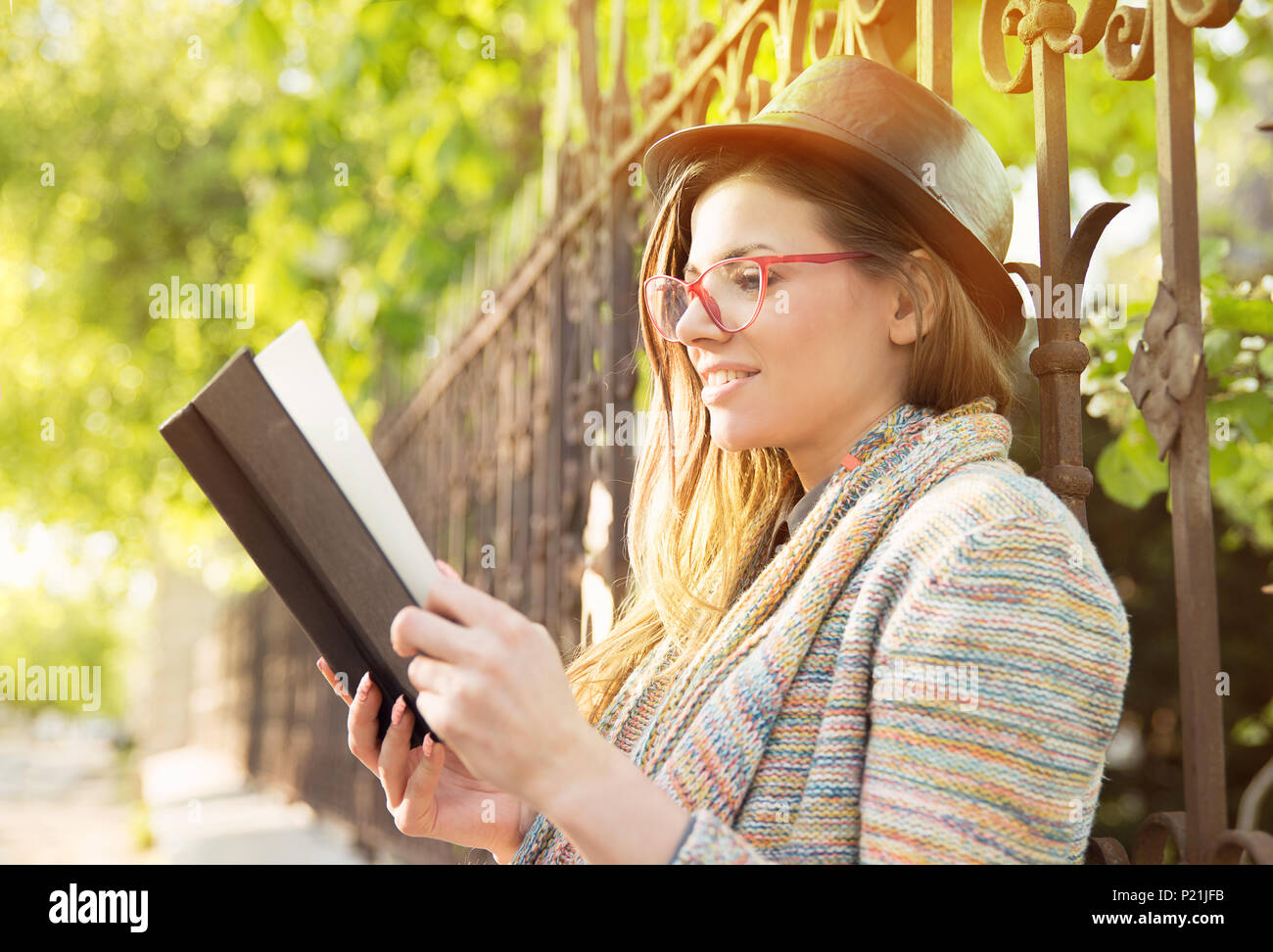 Young woman reading a book outdoors Stock Photo