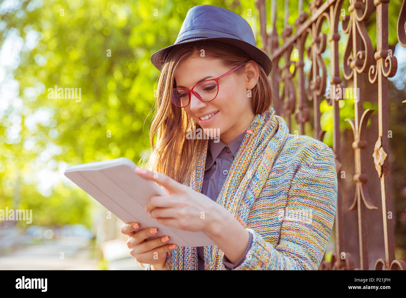Happy young woman using tablet computer outdoors Stock Photo