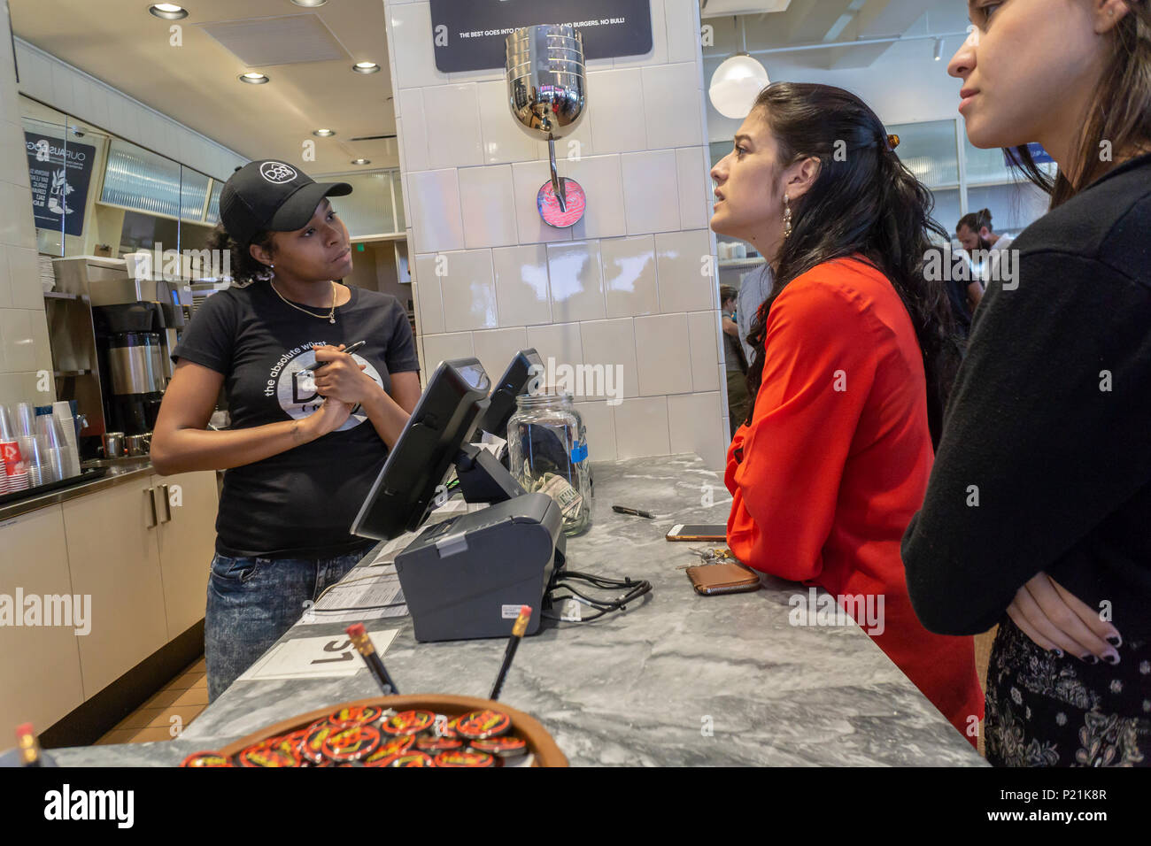 Customers place orders in the Dog Haus on opening day of their first New York store on Tuesday, June 12, 2018. Visitors were treated to a free hot dog as a welcome to their newest location in Soho. The chain specializes in fast casual dining of hot dogs, sausages, chicken  and burgers grilled on King Hawaiian rolls and topped with their signature 'builds'. Dog Haus was founded in 2010 in Pasadena, Caifornia with plans to open 300 new franchises by 2023. (Â© Richard B. Levine) Stock Photo