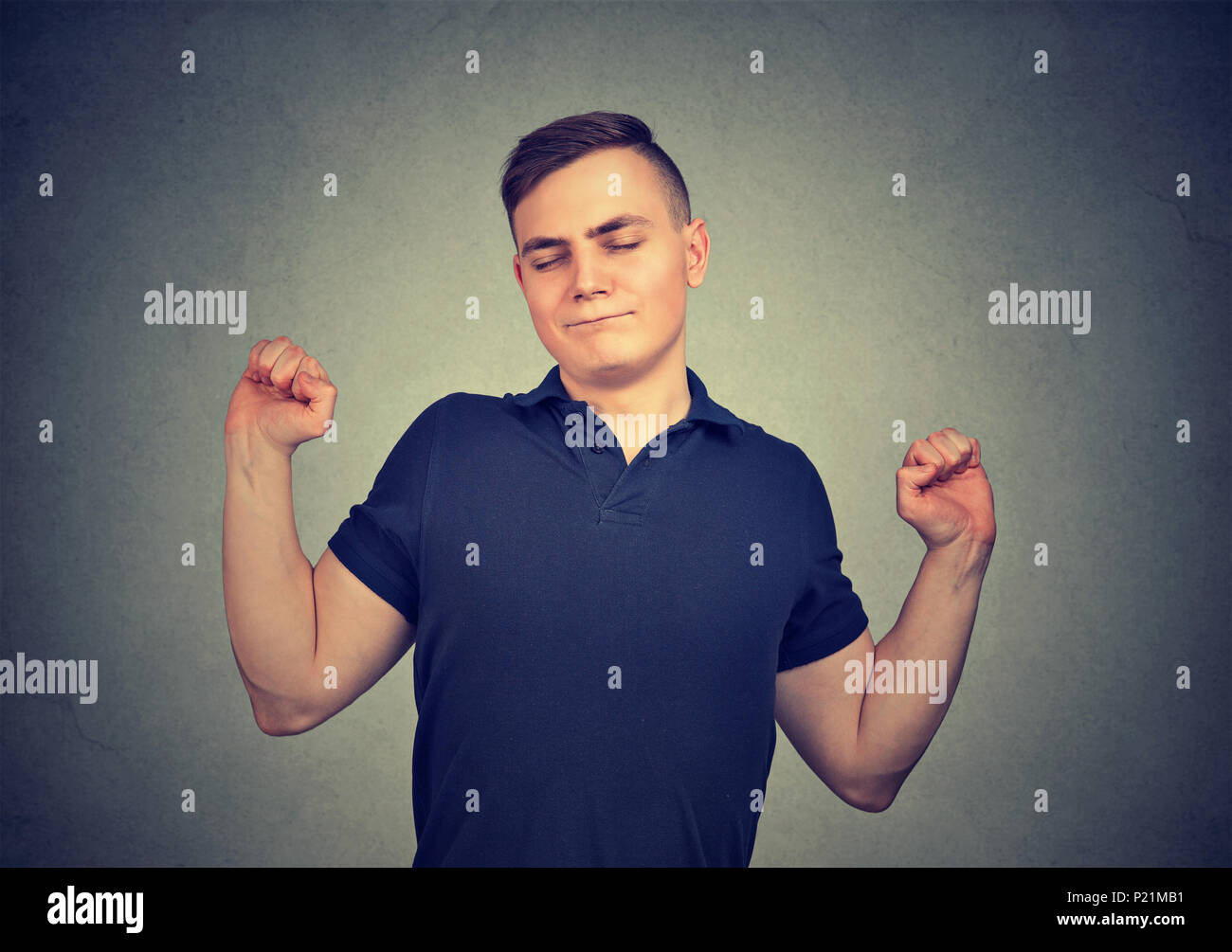 Sleepy man stretching arms back isolated on gray wall background. Sleep deprivation, burnout, concept Stock Photo
