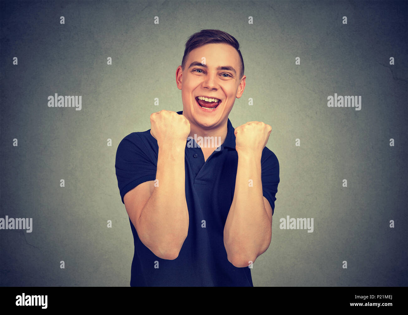 Successful student, man winning celebrating success isolated on gray wall background. Positive human emotion facial expression. Life perception Stock Photo