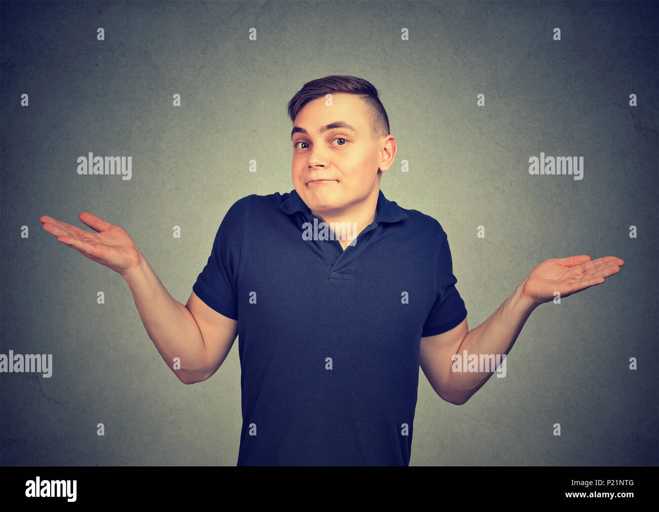 Ignorance. Man shrugging shoulders who cares so what isolated on gray background. Stock Photo