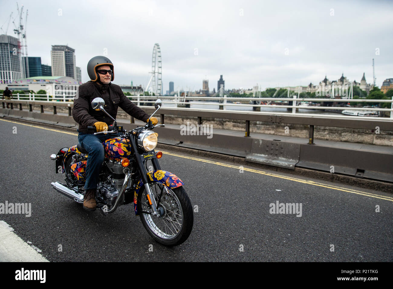 Jeremy Taylor riding the Dan Baldwin Royal Enfield bike over Waterloo Bridge during the photocall in London. PRESS ASSOCIATION Photo. Picture date: Tuesday June 12, 2018. A customised fleet of 12 Ambassador cars, eight Royal Enfield motorbikes, a tuk tuk and a Gujarati Chagda made up the 'Concours d'Ã©lÃ©phant' - a cavalcade of designer inspired, quintessentially Indian vehicles - while thirty beautifully decorated elephant sculptures will stand sentinel across the capital, ambassadors for their cousins in the wild. Stock Photo