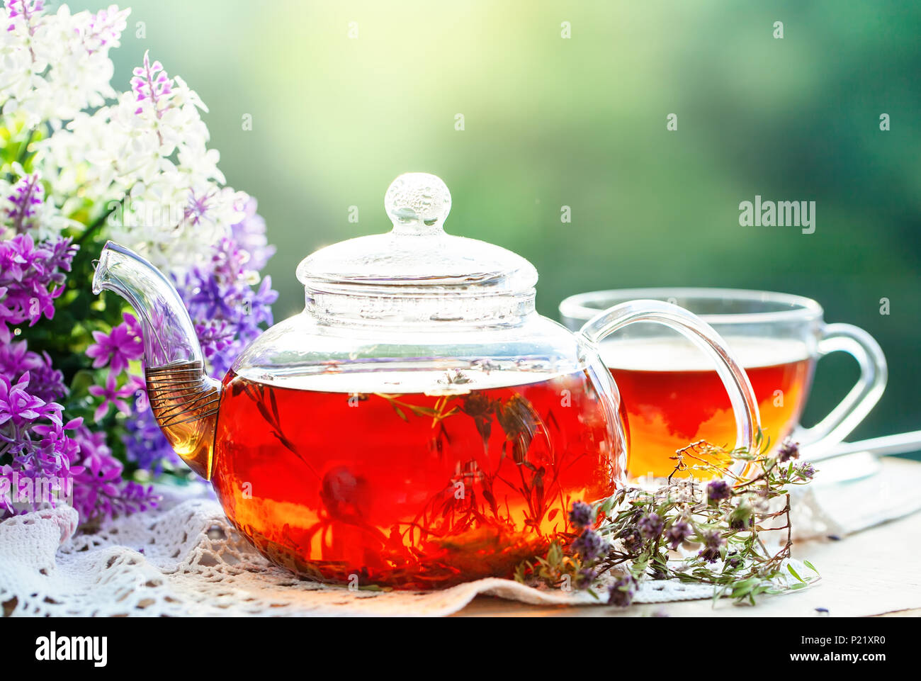 Cup with hot tea with mint and a thyme on a wooden table in a summer garden. Selective focus, Stock Photo