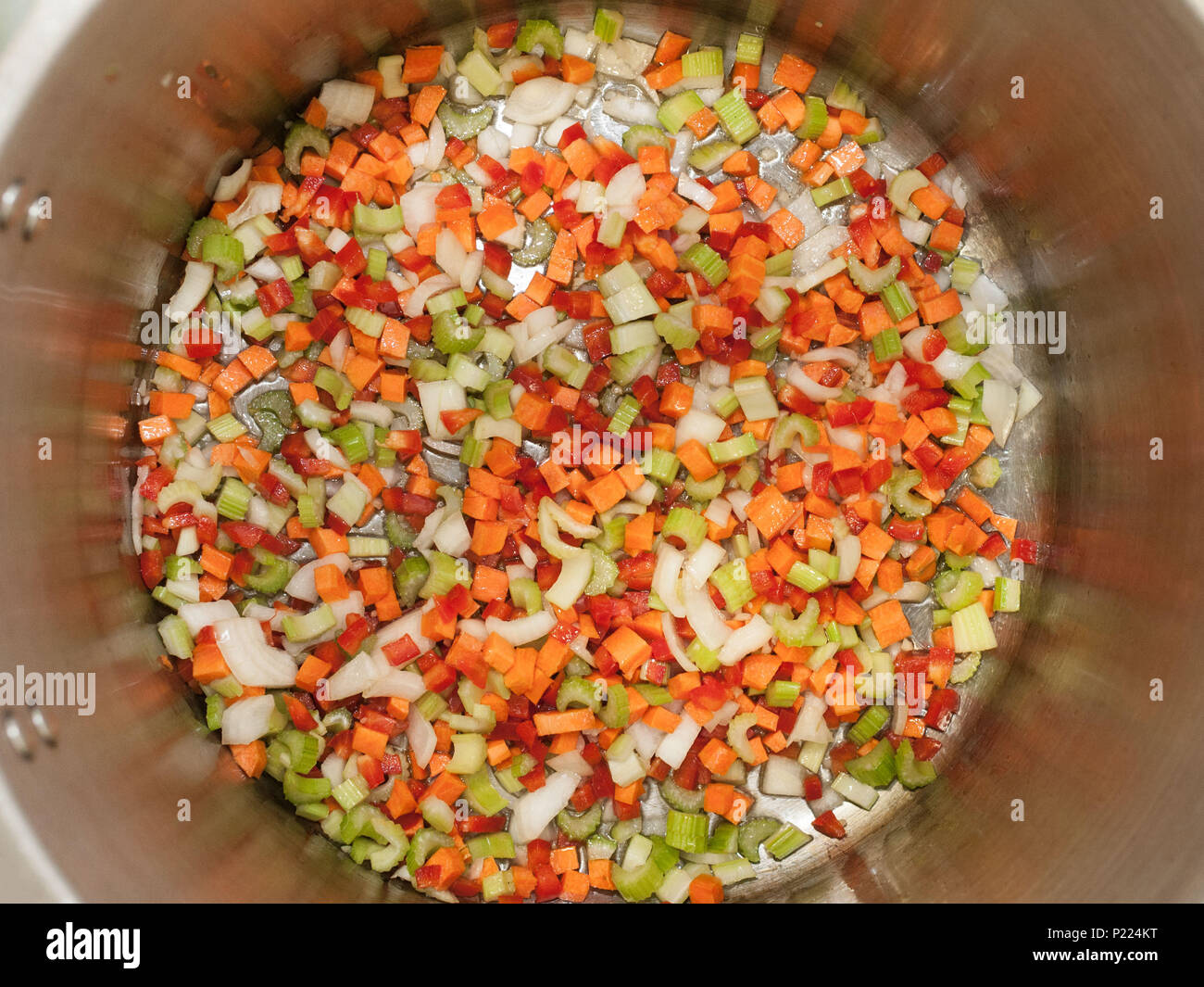 Diced vegetables frying in the bottom of a pot. Stock Photo